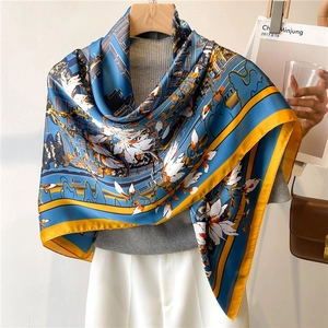 Detail of royal blue silk scarf featuring white floral prints and yellow contrast borders