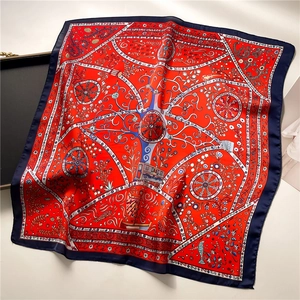 Close-up of elegant floral and wheel pattern on red and blue square silk scarf
