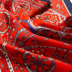 Close-up of red geometric floral silk scarf featuring vintage satin patterns and texture