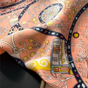 Close-up of silk-texture scarf showing detailed floral and geometric illustration prints