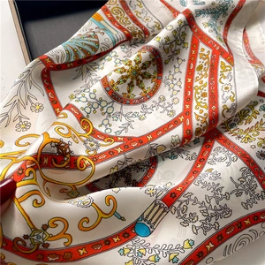 Detail of geometric floral silk scarf showing premium texture and rolled edges
