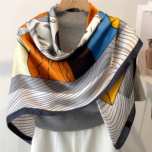 Close-up of artistic satin scarf with geometric patterns in orange and blue