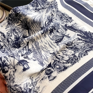 Blue and white Toile de Jouy silk scarf featuring palm tree and landscape patterns