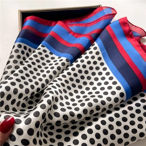 Close-up of silk-like scarf with classic polka dots and multi-colored striped edges