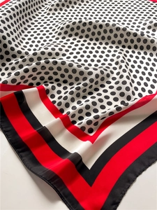 Detailed close-up showing the smooth satin texture and polka dot pattern of the silk scarf
