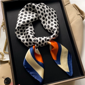 Detailed texture of satin scarf with polka dots and colorful geometric stripes
