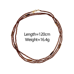Close-up of tiger eye stone cylinder and garnet beads on 120cm layered necklace