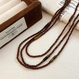 Detailed macro of vintage multi-layered tiger eye stone beads and polished brown crystals