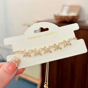 Dettaglio di un bracciale a farfalla dorato regolabile con zirconi scintillanti