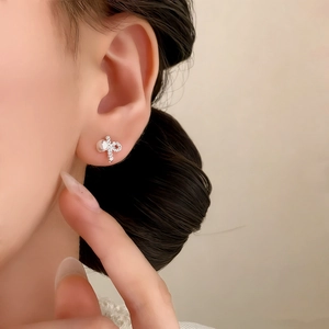 Elegant silver bow earrings with sparkling pave diamonds and a lustrous white pearl