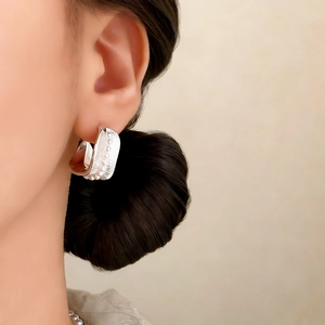 French retro silver C-shaped textured earrings with bead detail worn by a model