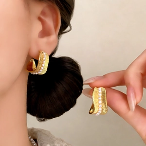 French vintage gold textured earrings with white pearls shown on a model's ear