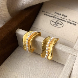 Detailed close-up of French vintage gold-plated earrings with texture and pearls