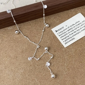 Dettaglio di una collana d'argento con accenti di cristallo e sfere di metallo lucido