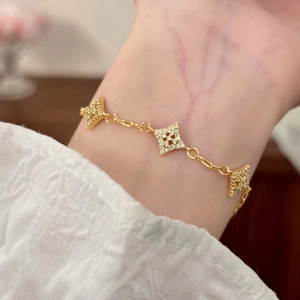 Detail of elegant gold star bracelet with pave-set zircon stones on a female wrist