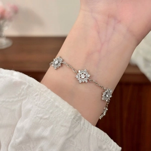 Elegant silver snowflake bracelet with micro-set zircon stones on model's wrist