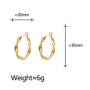 Golden twisted hoop earrings with 30mm diameter and glossy textured metal finish