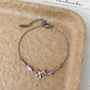 Bracelet élégant en acier inoxydable avec cœurs roses et détail de breloque en nœud