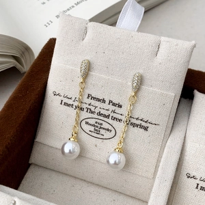 Macro view of French tassel earrings with micro-set zircon and high-luster pearls