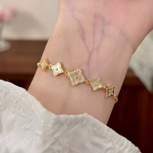 Elegant adjustable gold bracelet with mother of pearl and zircon four-leaf motifs