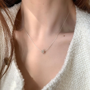 Collier chaîne argentée minimaliste avec pendentif fleur 3D porté par un mannequin