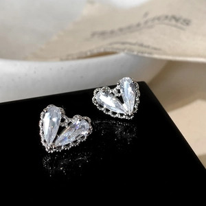 Vista macro degli orecchini a cuore argento con pietre a goccia e bordo con perline