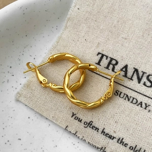 Französische Vintage-Stil goldene gedrehte Creolen auf einer Keramikplatte
