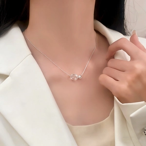 Elegant silver snake chain necklace with oval pendant worn by model in white suit