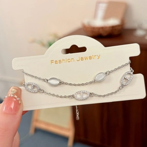 Vista dettagliata di un bracciale a doppio strato con opale bianco e charms naso di maiale