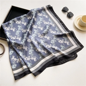 Detail of luxury satin silk scarf featuring vintage carriage patterns and striped borders