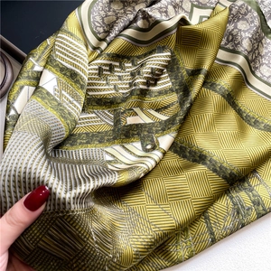 Close-up of printed silk satin scarf showing floral and geometric patterns and smooth texture