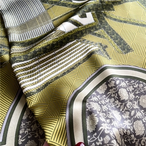 Macro shot of elegant olive green silk scarf fabric with floral and geometric motifs