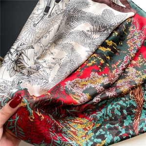 Close-up of printed silk scarf showing fine rolled edges and tropical leaf patterns