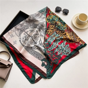 Detail of floral printed satin scarf with a high-contrast artistic forest pattern design