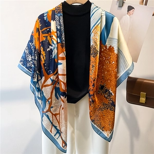 Artistic printed silk scarf with abstract tree patterns draped on a minimalist outfit