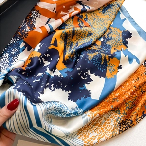 Detailed view of silky satin scarf texture with artistic tree pattern and blue lines