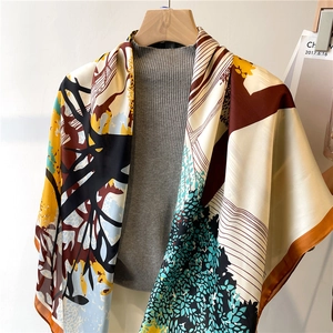 Artistic abstract tree print silk scarf detail showing elegant drape on a grey sweater
