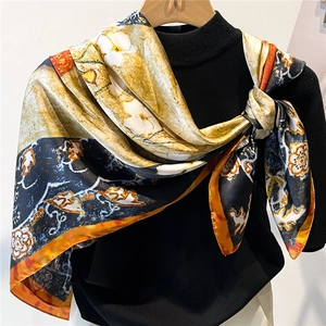 Detail of elegant satin scarf with vintage floral and baroque patterns on a black sweater