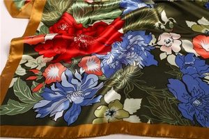 Detail view of satin floral scarf with elegant blooming flowers and silk-like texture