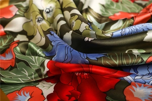 Close-up of elegant floral satin scarf featuring vivid patterns and glossy silk texture