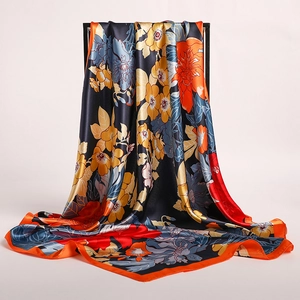 Detailed view of floral satin scarf with orange borders and elegant drapery texture