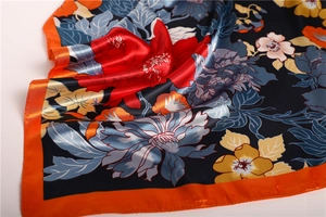 Detail of elegant satin scarf showing vibrant peony floral print and smooth silk texture