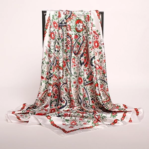 Close-up of floral paisley silk scarf with red and navy patterns on cream fabric