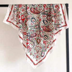 Detail of bohemian paisley silk scarf showing flowing satin texture and intricate floral print