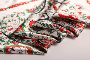 Macro shot of elegant floral satin scarf showing silk texture and vintage vine patterns