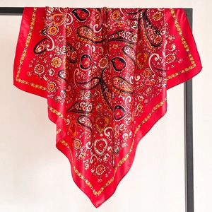 Close-up of red paisley pattern silk scarf showing drape and glossy satin texture