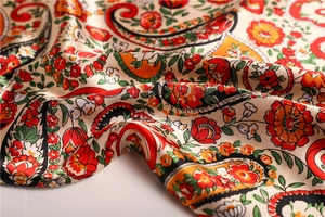 Detail of floral paisley pattern silk scarf with elegant satin finish and rich colors
