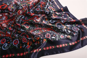 Detail of navy blue paisley satin scarf showing smooth silky texture and floral print