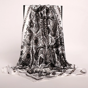 Detail of silk-like satin scarf featuring black and white paisley and floral patterns