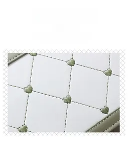 Détail de la broderie cœur sur la surface du sac en cuir blanc matelassé